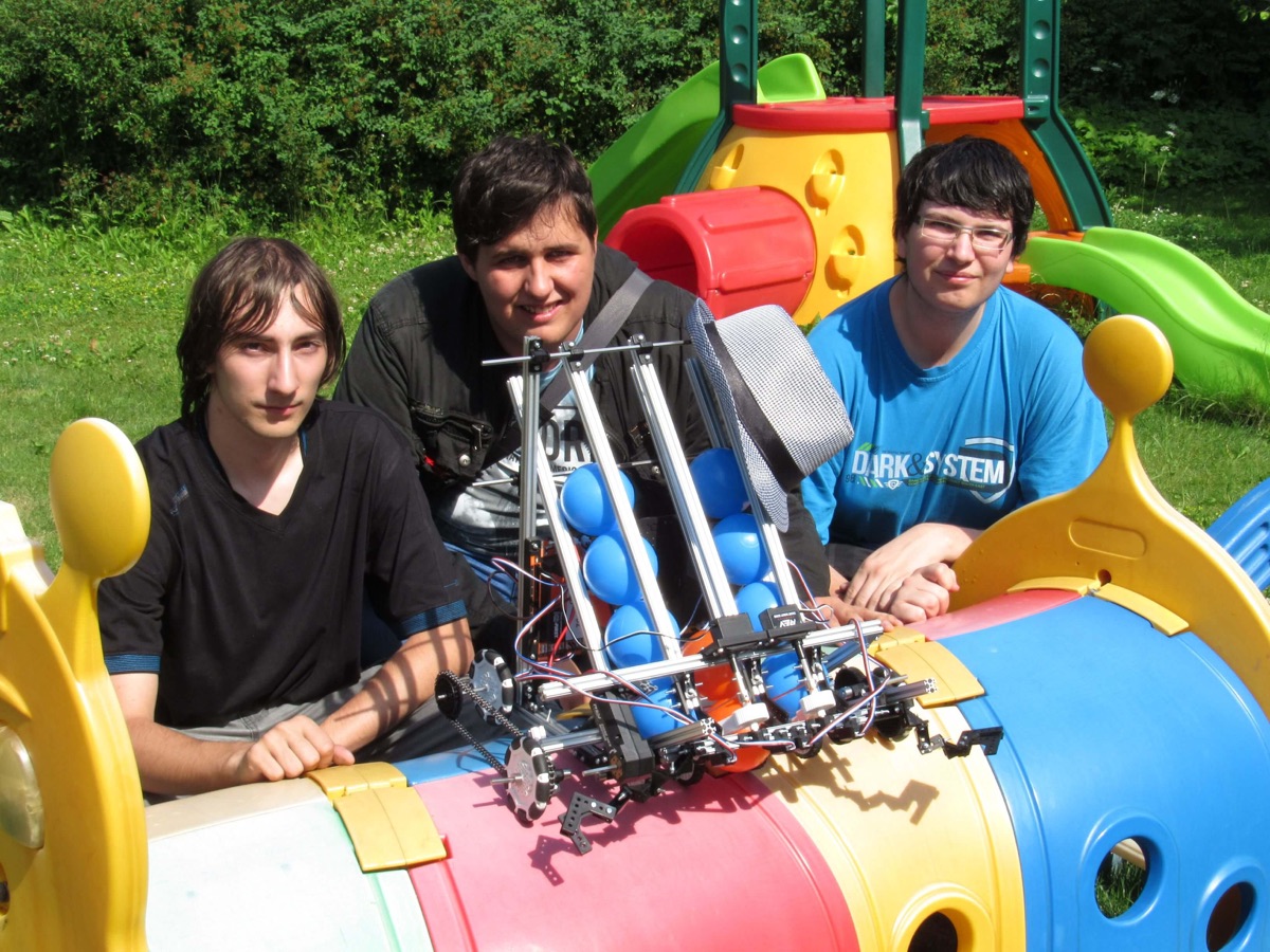 Three students from Team Czech Republic 2017 posing with their robot